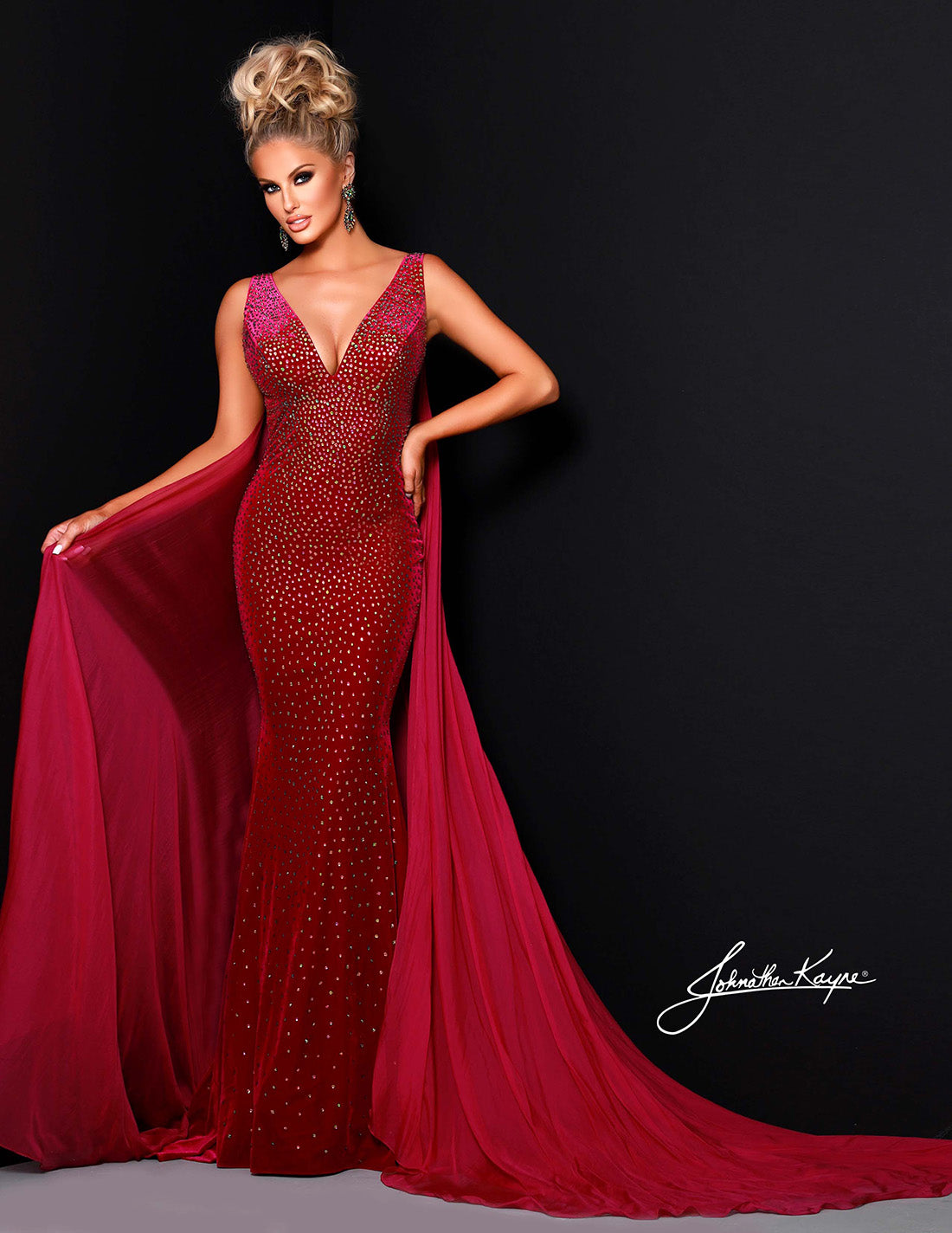 The Johnathan Kayne 2308 Long Velvet Crystal Pageant Dress is the perfect choice for a formal event. This stunning prom gown features a V-neck train and is embellished with exquisite crystals for a look that is sure to dazzle. With its high-quality velvet fabric, you'll have no trouble making a statement. This head to toe crystal shimmering stretch velvet dress is sure to be a winner. 