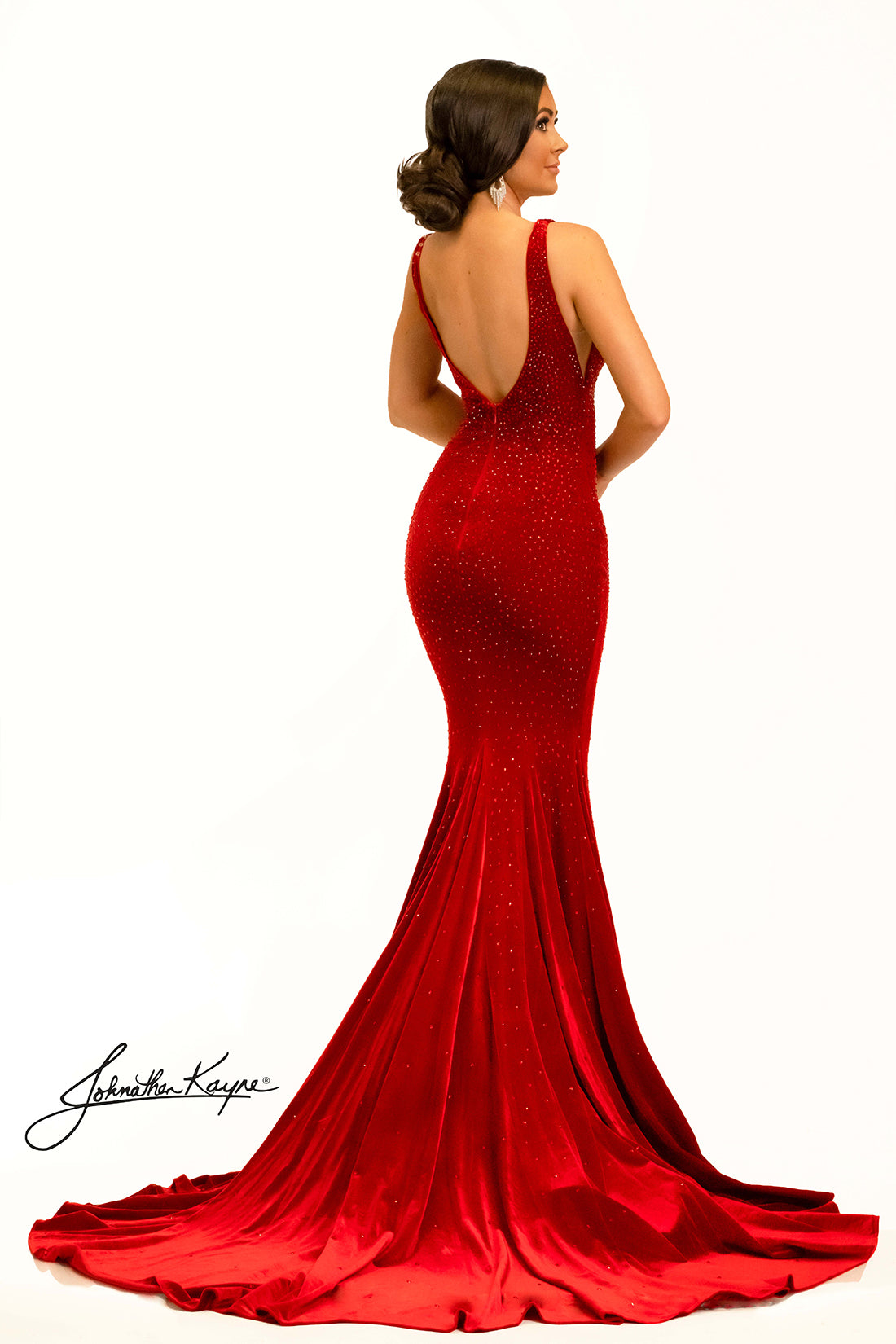 The Johnathan Kayne 2308 Long Velvet Crystal Pageant Dress is the perfect choice for a formal event. This stunning prom gown features a V-neck train and is embellished with exquisite crystals for a look that is sure to dazzle. With its high-quality velvet fabric, you'll have no trouble making a statement. This head to toe crystal shimmering stretch velvet dress is sure to be a winner. 