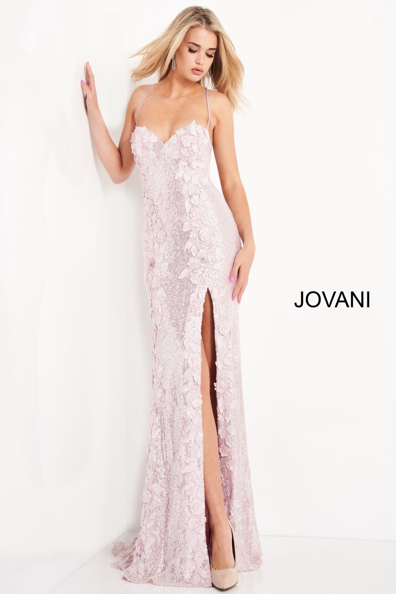 Jovani 06109 is a Long Fitted Sequin Embellished Formal Evening Gown. This Sweetheart neckline prom dress has spaghetti straps that lead around to an open back with a lace up corset tie closure. Detailed 3D Floral Appliques Embellished the fitted bodice & Cascade down the length of this gorgeous Pageant Gown. Thigh Slit in Skirt. Embellishments also adorn the back length of the Gown trailing into a Lush sequin sweeping train.