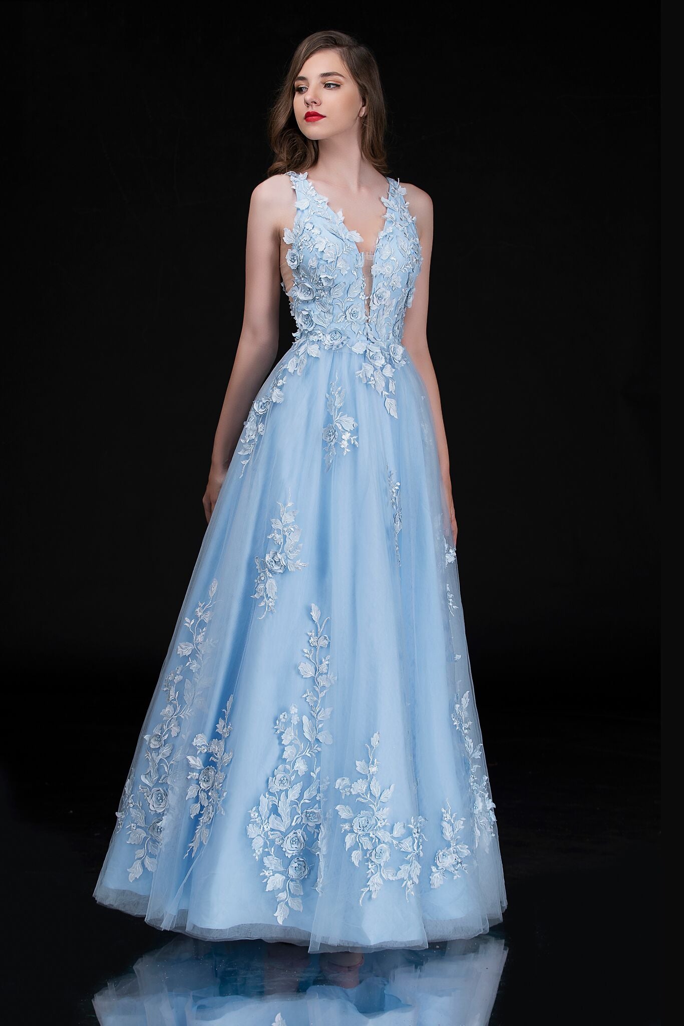 Nina Canacci 1495 is a long 3d Floral Applique embellished Deep V Neck Prom Dress. This Romantic formal gown features embellished floral appliques cascading into the tulle A Line Ballgown Skirt. Great Formal dress.  Available Sizes: 0-10  Available Colors: Ice Blue, Ivory