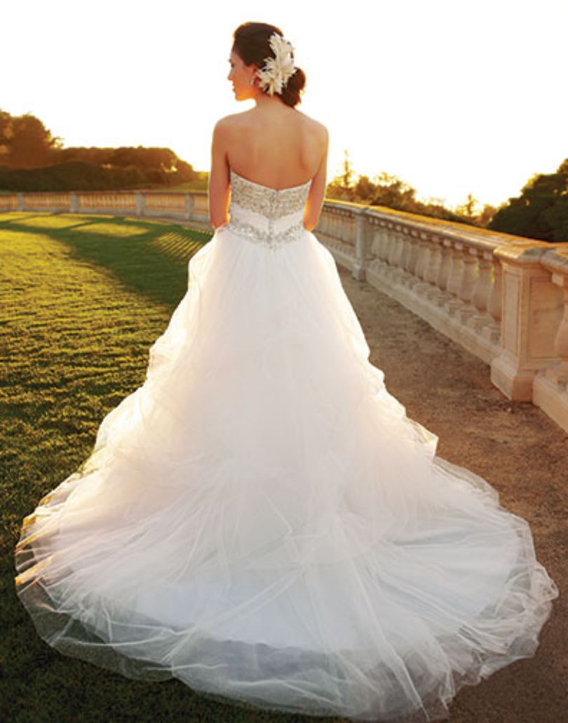 Casablanca Bridal 2052 Soft Tulle pick-ups over Silky Satin accented with heavily beaded bodice and a ruched Tulle waistband this wedding dress is over the top romantic.   Color:  Ivory/Ivory/Silver  Fabric: Tulle over Silky Satin with Beaded and Embroidered bodice.  This is a size 6 in Ivory & Silver