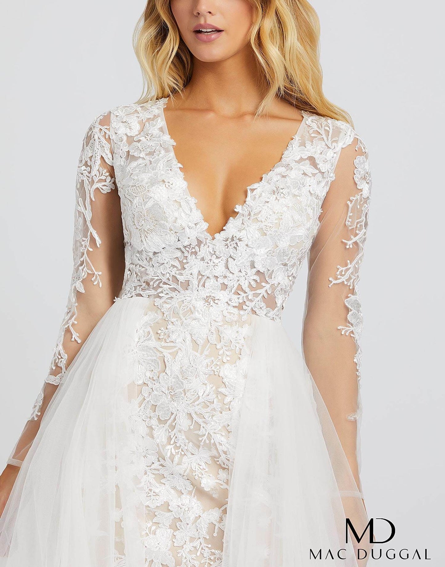 Mac Duggal 26322M - 26322 Love this dress so much you’ll want to re-wear it for your wedding! Style 26322M is an ivory nude ball gown with sheer long sleeves, a v-neckline, and overskirt. This incredible gown has embroidery detailing from head to toe. 