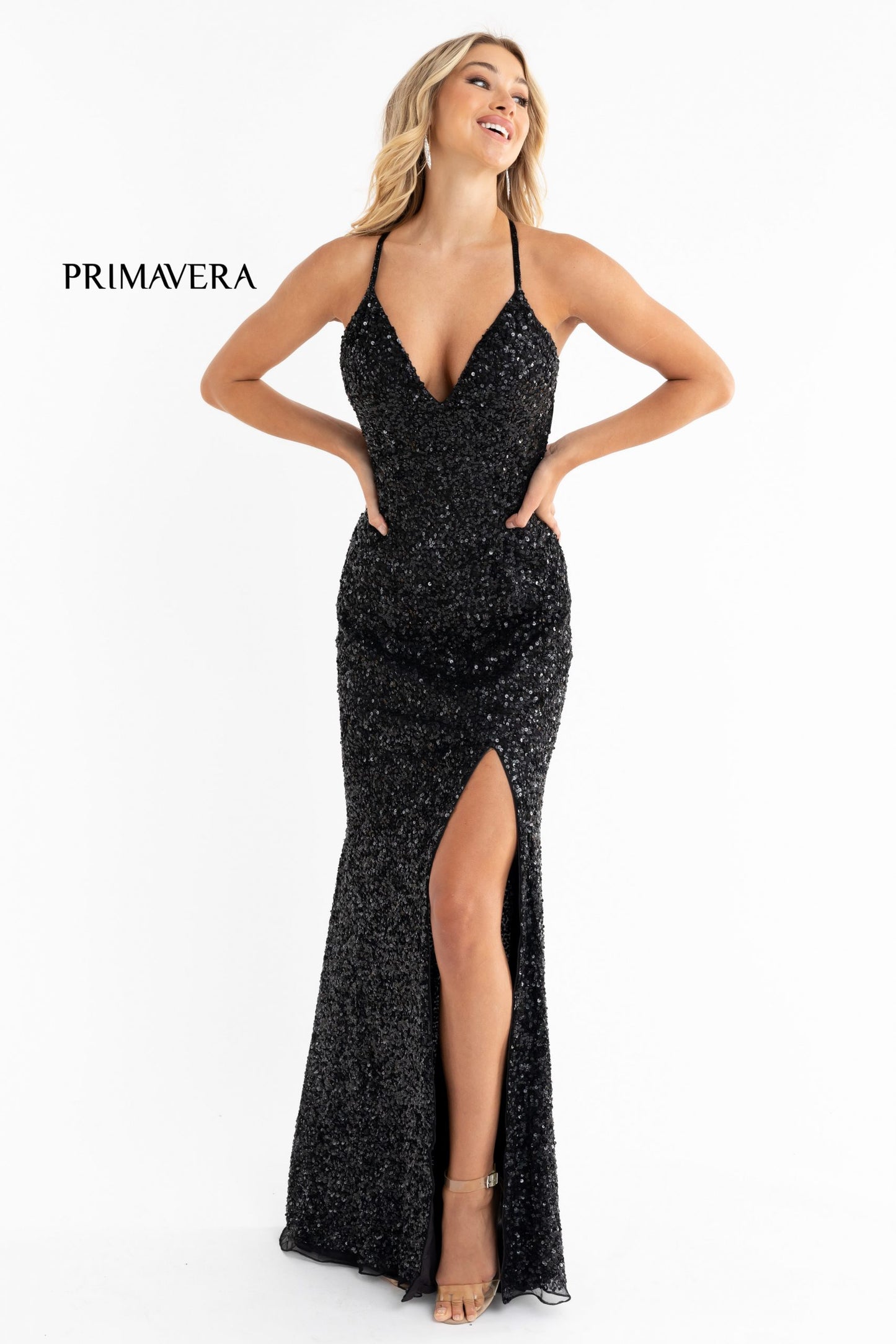 Primavera Couture 3291 Exclusive Prom Dresses.  This long prom dress is embellished throughout with shimmering sequins.  This impressive gown showcases a v neckline, thin beaded straps and crisscrossed straps in the open back. The long slim skirt has a sultry high side front slit. 