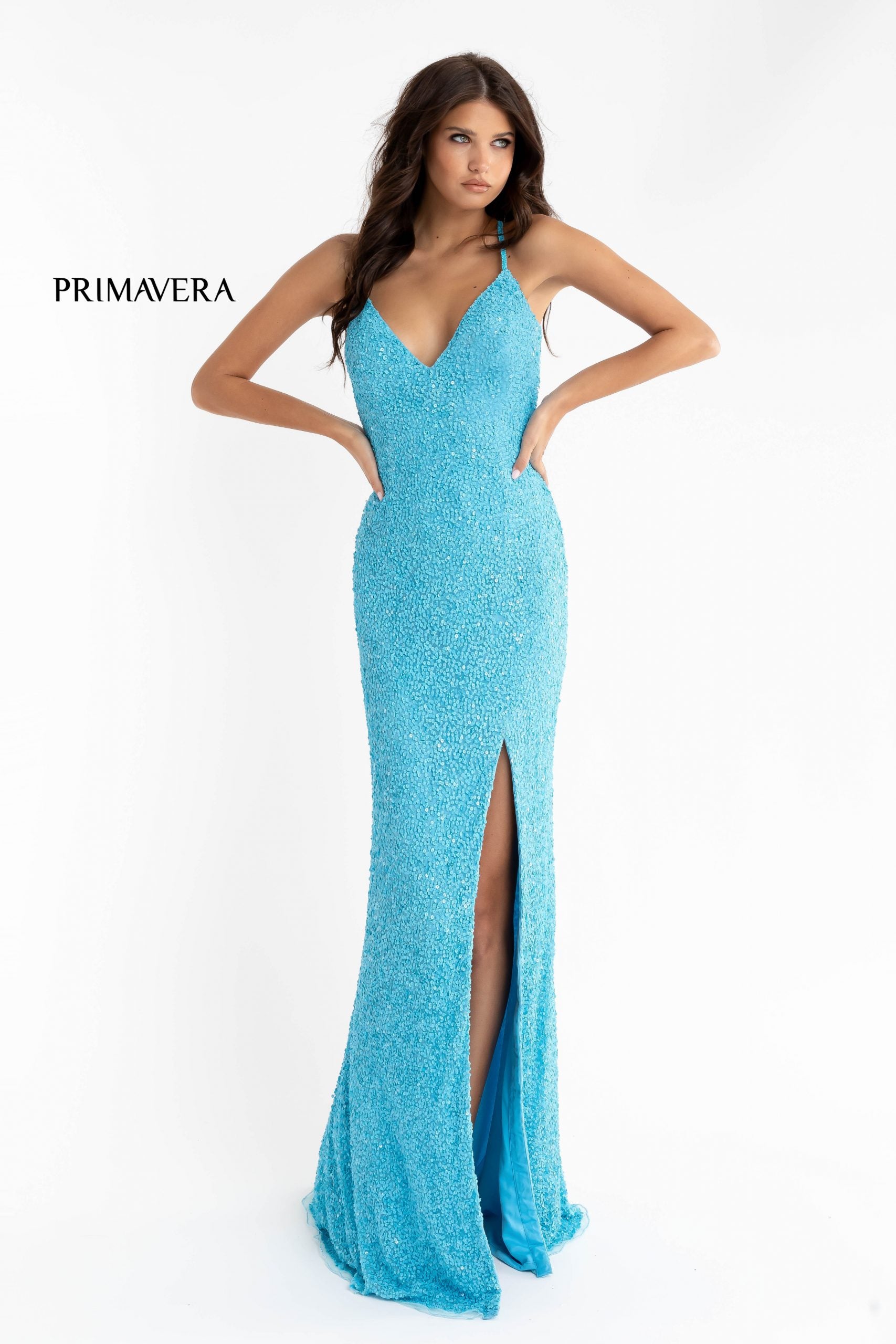 Primavera Couture 3291 Exclusive Prom Dresses.  This long prom dress is embellished throughout with shimmering sequins.  This impressive gown showcases a v neckline, thin beaded straps and crisscrossed straps in the open back. The long slim skirt has a sultry high side front slit. 