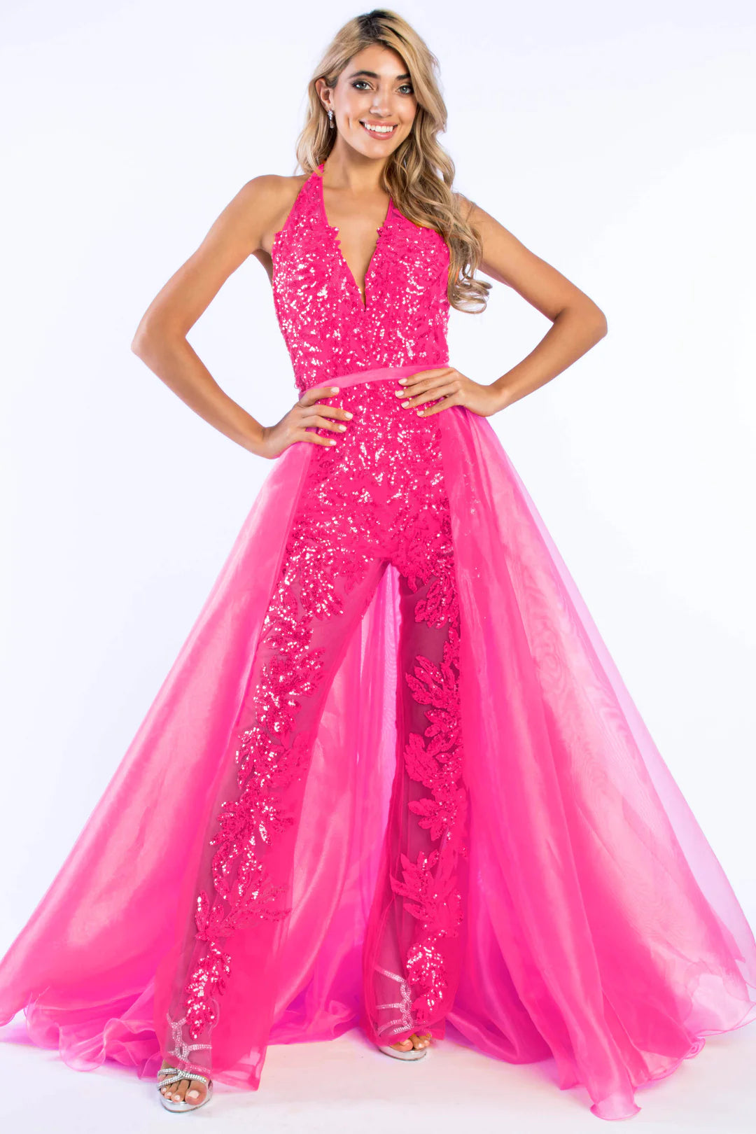 Ava Presley 37381 is crafted with a long, sheer sequin halter jumpsuit, detachable overskirt, V-neck backless design, and a hint of fun fashion. The result is a luxurious, glamorous look perfect for pageants.  Sizes: 0-16  Colors: Royal, Fuchsia, Iridescent Orange