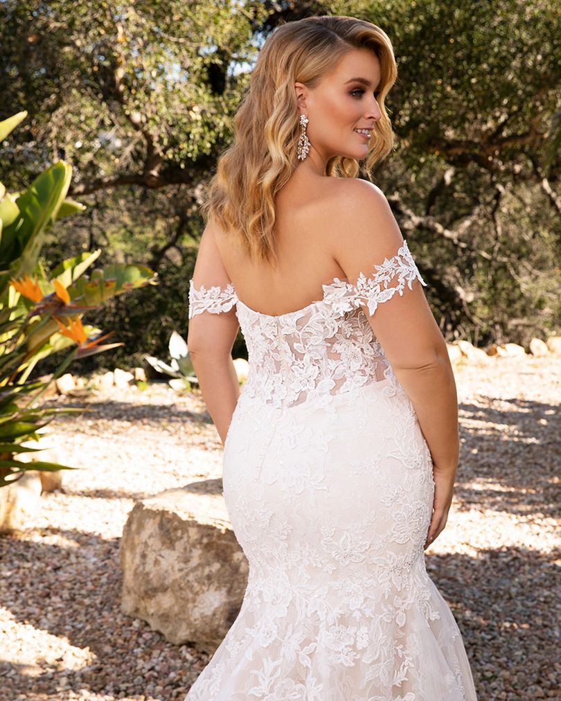 Style 2376 KARINA by Casablanca Bridal is a glamorous twist on the classic lace wedding dress. Off-shoulder sleeves transition into a classic sweetheart neckline, while floral lace swirls all throughout the fit-and-flare silhouette. The illusion back, lined with a row of subtle crystal buttons, transitions flawlessly into a gently scalloped train. A matching, two-tier cathedral length veil is available for the bride who wants to make an extra remarkable impact.  Size: 10, 14, 20  Ivory/Nude/Ivory/Silver