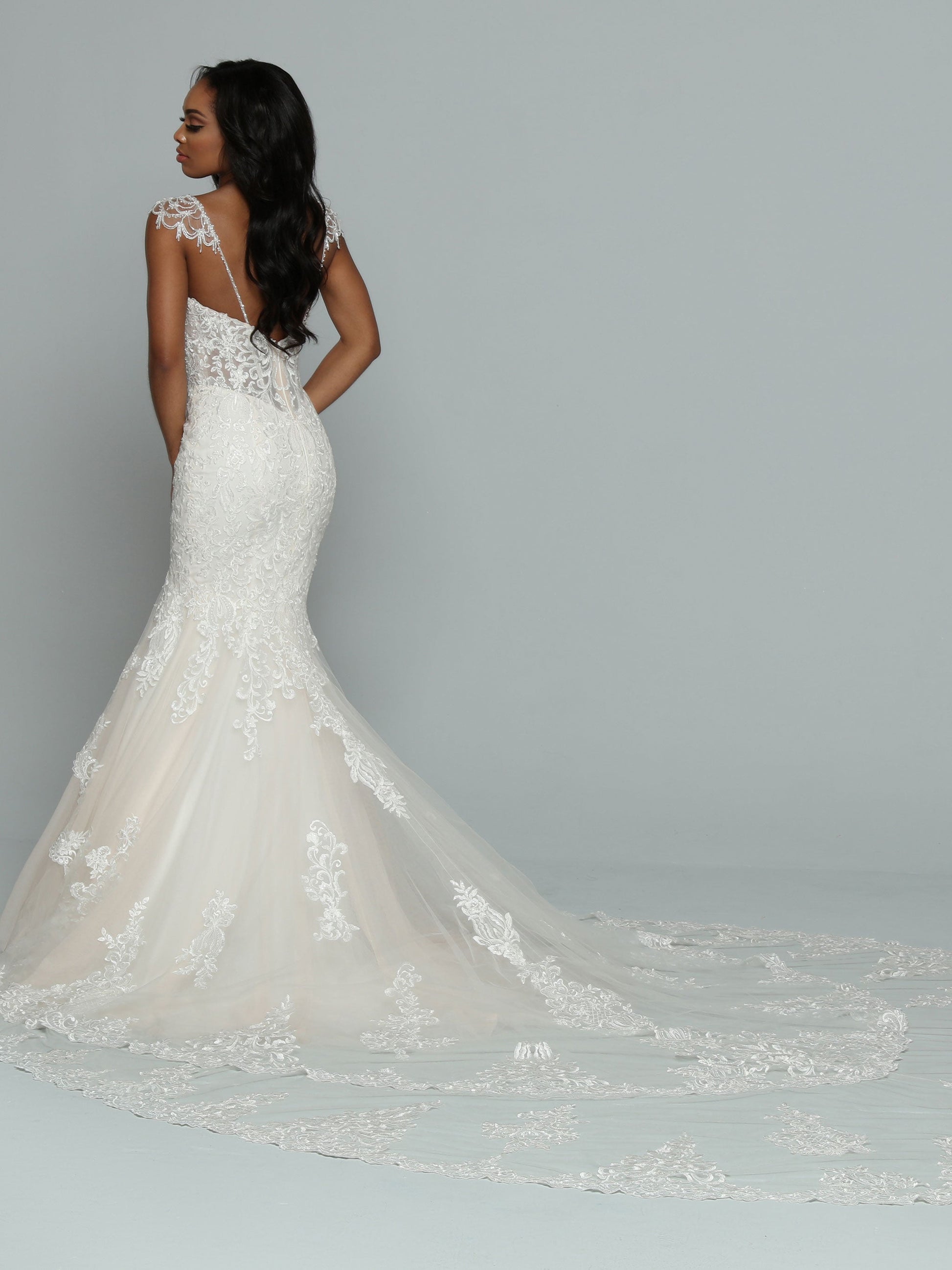 Davinci Bridal 50662 is a stunning long lace formal wedding dress. mermaid silhouette with a sheer lace corset bodice and crystal cap sleeves. Long double layered train with lace embellishments.  Available Size: 14  Available Color: Ivory/Ivory