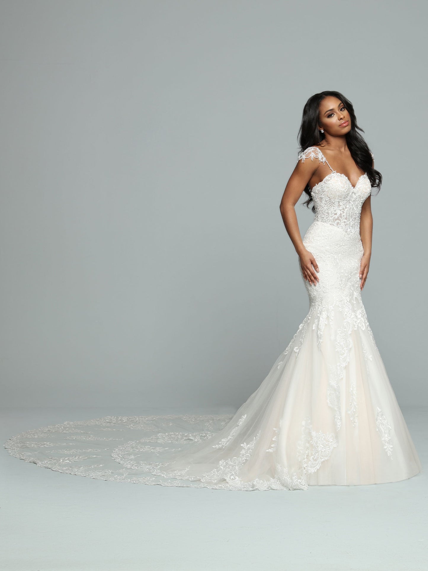 Davinci Bridal 50662 is a stunning long lace formal wedding dress. mermaid silhouette with a sheer lace corset bodice and crystal cap sleeves. Long double layered train with lace embellishments.  Available Size: 14  Available Color: Ivory/Ivory