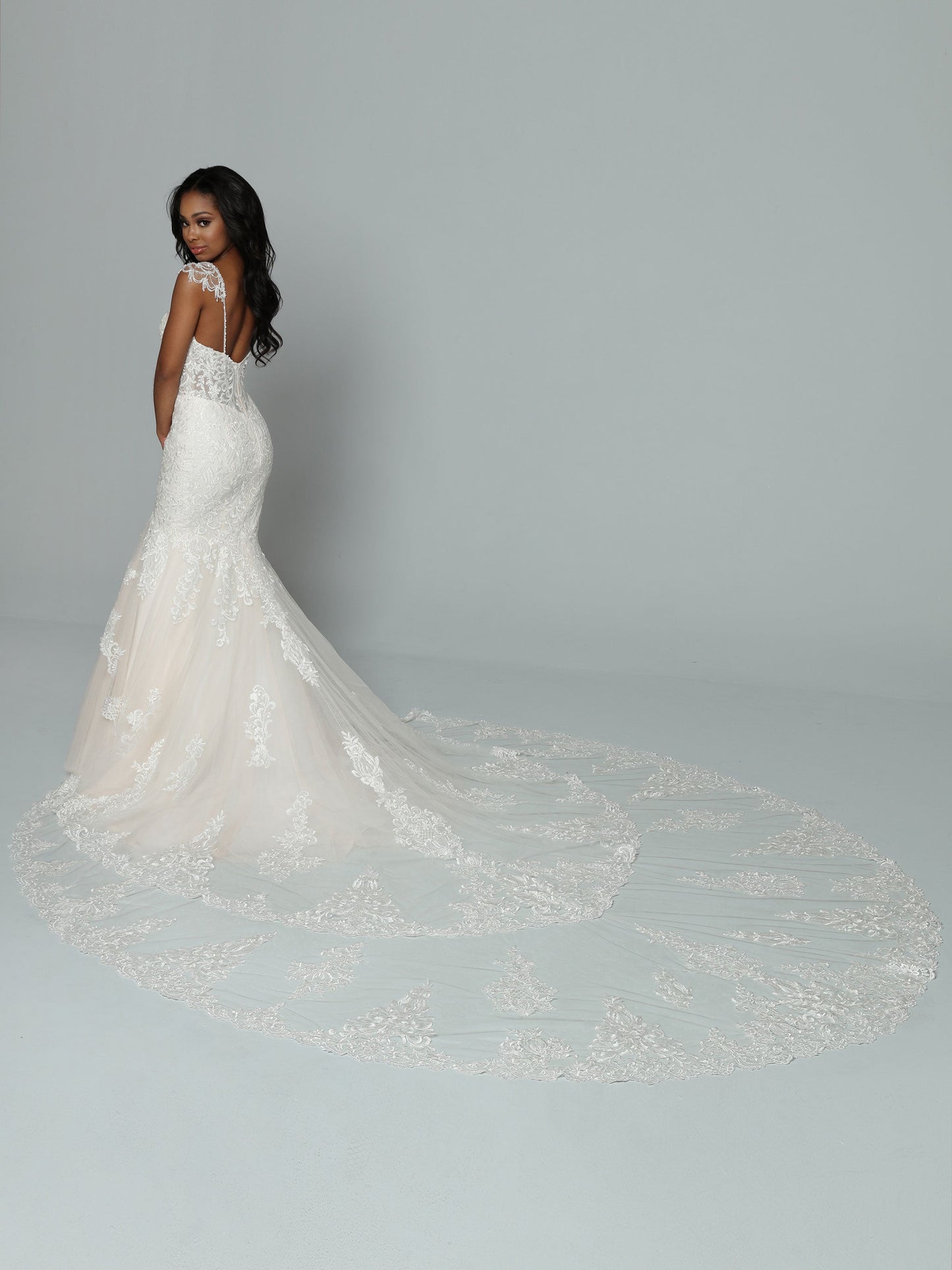 Davinci Bridal 50662 is a stunning long lace formal wedding dress. mermaid silhouette with a sheer lace corset bodice and crystal cap sleeves. Long double layered train with lace embellishments.  Available Size: 14  Available Color: Ivory/Ivory