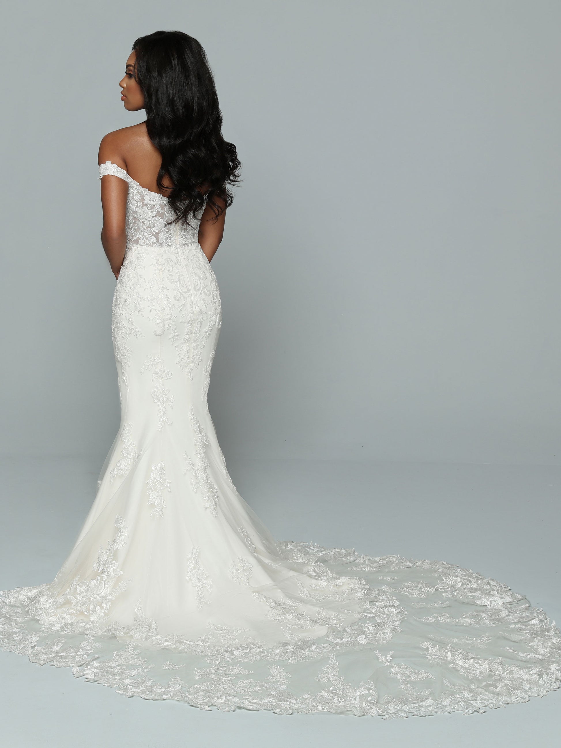 Davinci Bridal 50664 is a stunning lace fit & Flare formal bridal gown. off the shoulder lace straps and a sheer lace fitted bodice. Long tulle lace embellished train. Great sultry wedding style!   Available Size: 16  Available Color: Ivory/Ivory