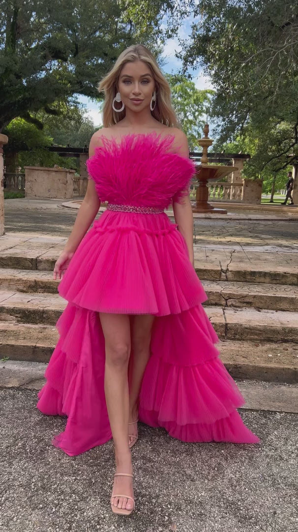 Make a statement in the stunning Ava Presley 38882 Prom Dress. This eye-catching piece features a high-low silhouette adorned with ruffle layered pleats, ruffles at the neck, and feathers. Enchanting and elegant, it's a perfect choice for prom, formal or pageant events. Strapless Feather Bodice with a rhinestone & beaded waist belt.  Sizes: 00-18  Colors: Red, Hot Pink