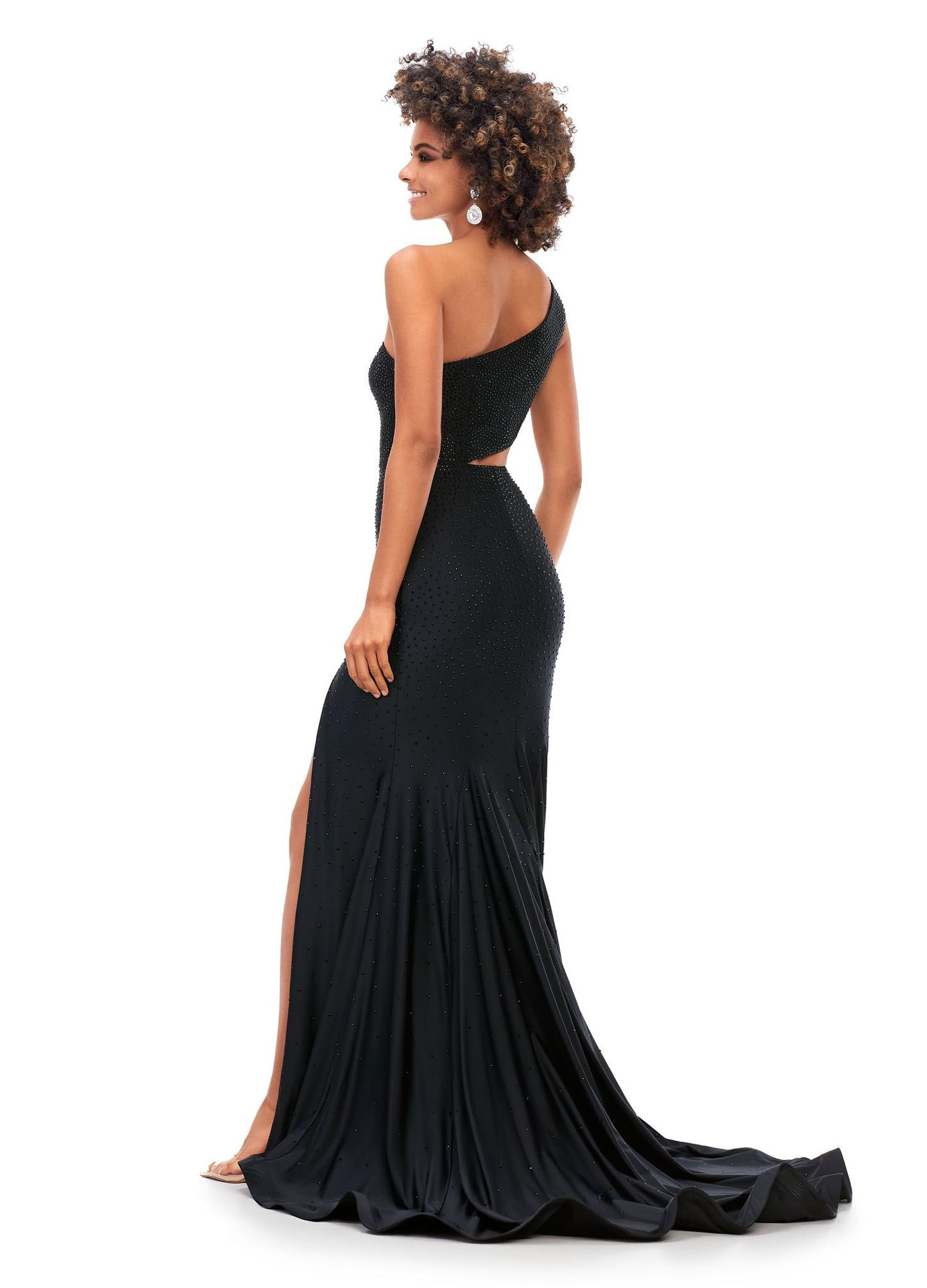 Ashley Lauren 11337 Stand out in this fitted one shoulder jersey gown embellished with heat set stones. The look is complete with an asymmetrical sharkbite cut out and left leg slit. One Shoulder Cut Out Heat Set Stones Jersey COLORS: Hot Pink, Turquoise, Black, Red, Violet