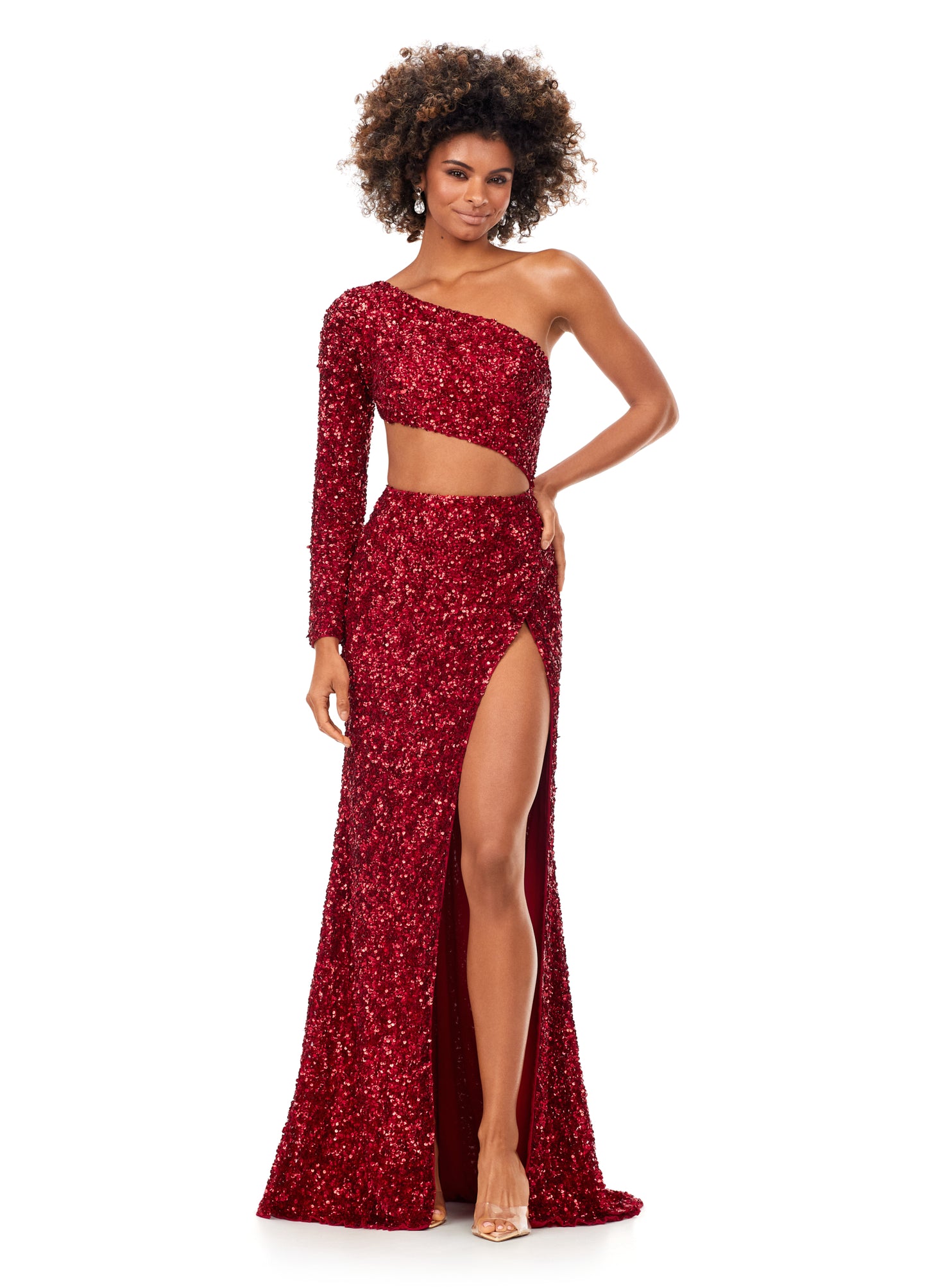 Ashley Lauren 11340 This sequin one shoulder gown features one sleeve and a shark bite cut out. The gown is complete with a left leg slit.