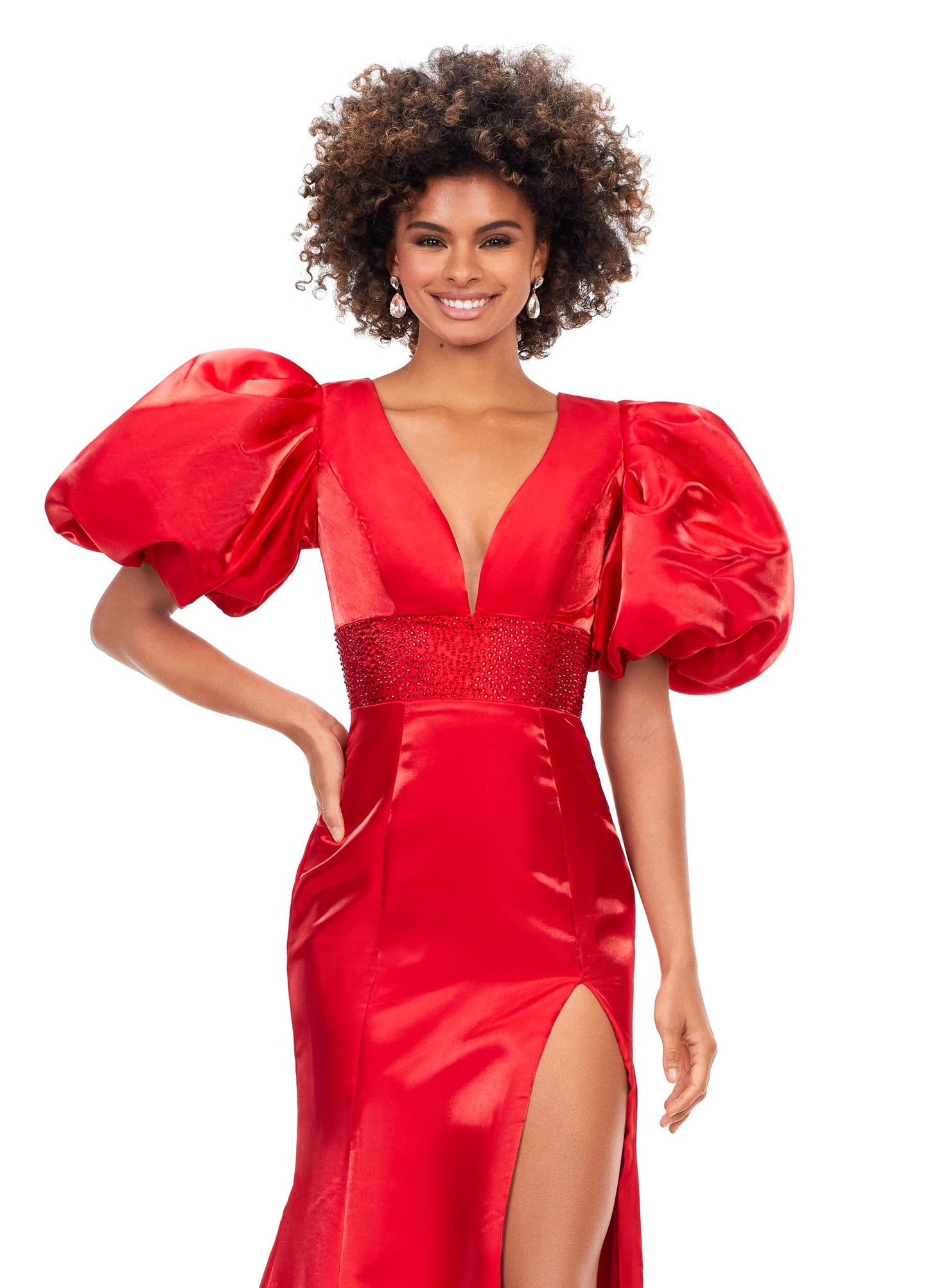 Ashley Lauren 11379 Shine in this v-neckline dress that features oversized puff sleeves. The waistband is embellished with scattered heat set stones and is complete with a lace-up back. V-Neckline Oversized Puff Sleeves Fitted Skirt Shimmer Satin COLORS: Aqua, Black, Red