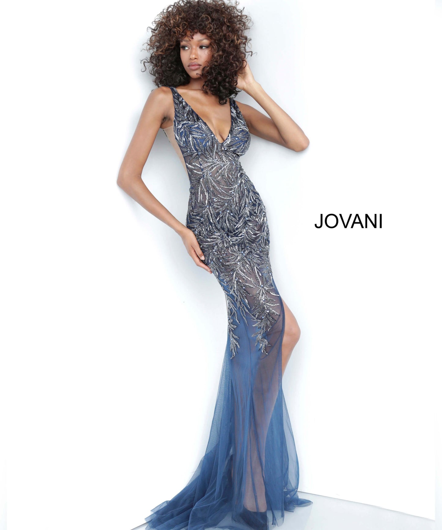 Jovani 1863 is a Gorgeous sheer Fully embellished Plunging Deep v neckline prom dress & Formal evening gown with slit in the sheer column skirt. Fully Embellished Crystal accented beaded sheer fitted bodice. Sheer side panels with mesh inserts.   Available colors:  Navy, Red, Silver/Nude, White  Available sizes:  00-24 