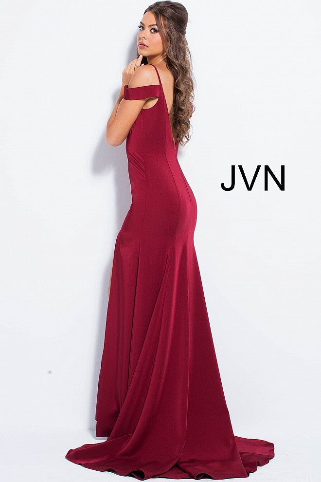 The JVN57297 prom dress from JVN by Jovani features an off the shoulder design and a side slit in a rich Burgundy color. This floor length dress includes a train, form fitting bodice, plunging neckline with a sheer mesh insert, and spaghetti straps over the shoulders. The V back adds an elegant touch to this stunning gown.