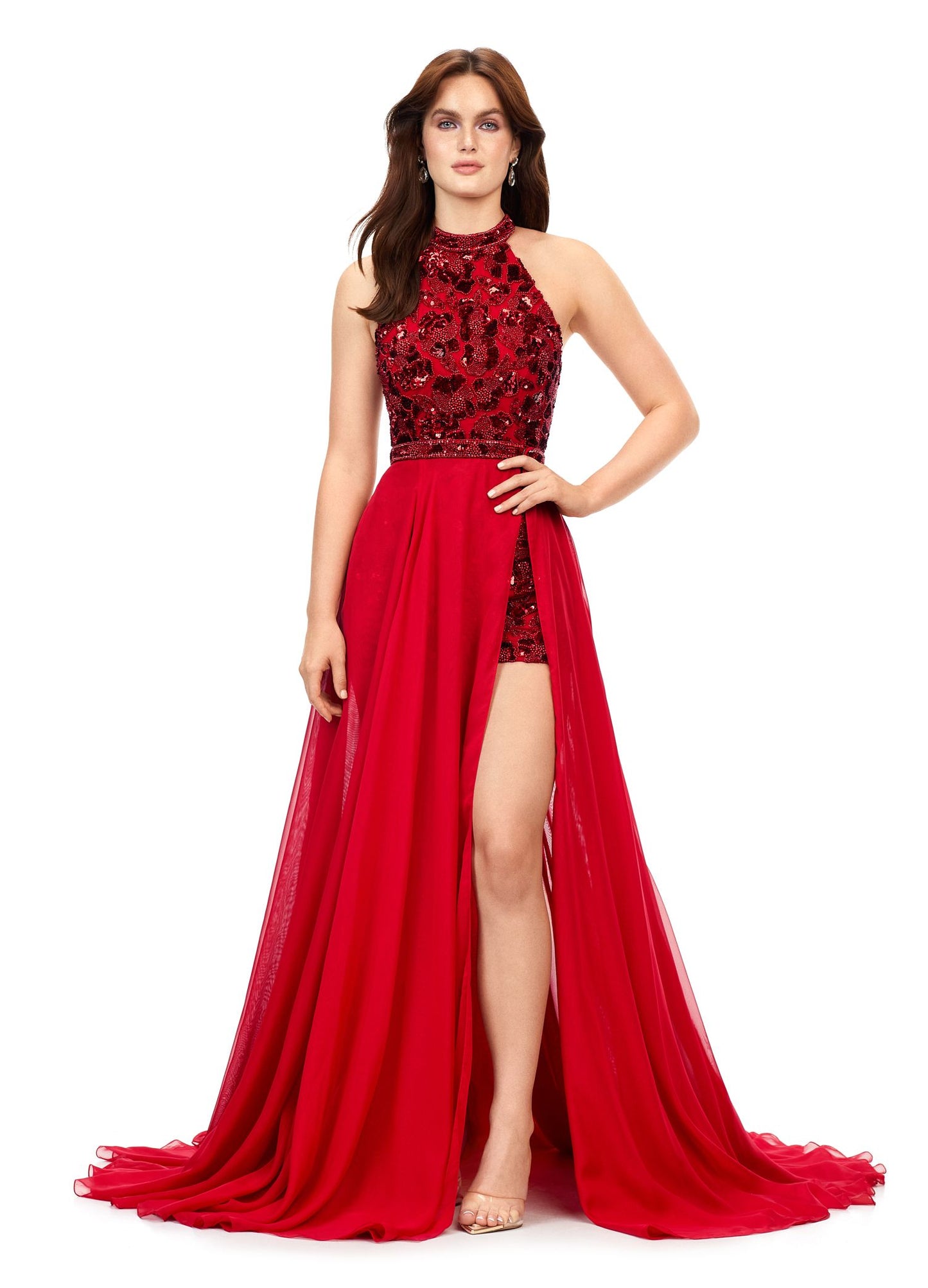 Ashley Lauren 11354 This halter romper features an intricately beaded floral motif throughout. The look is complete with a chiffon detachable skirt and beaded belt. Halter Neckline Romper Detachable Chiffon Overskirt Fully Hand Beaded COLORS: Black, Red, Ivory, Royal, Orchid/Pink