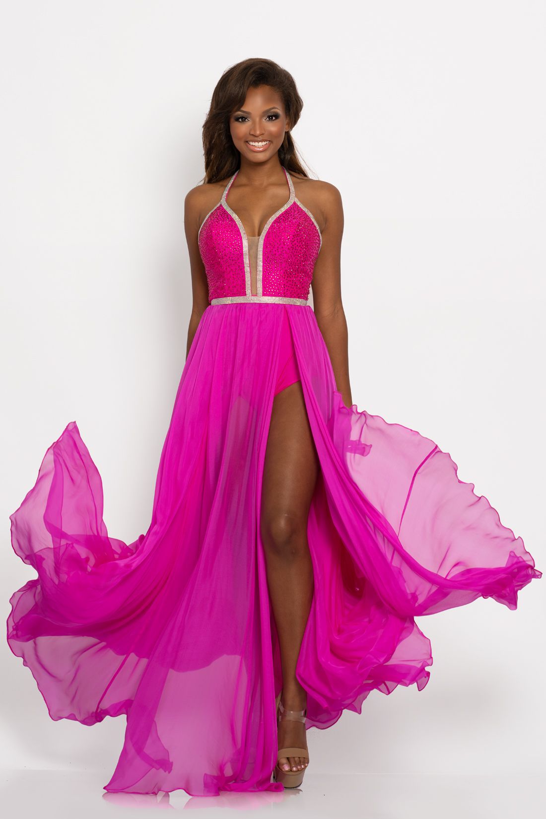 Johnathan Kayne 2219 This exquisite bodysuit has an embellished bodice with a plunging neckline with mesh panel and is outlined in crystal embellishments.  The back is open and the overskirt is long flowy chiffon with a side slit up to the waistline.  Colors  Fuchsia, Navy, White  Sizes  00, 0, 2, 4, 6, 8, 10, 12, 14, 16